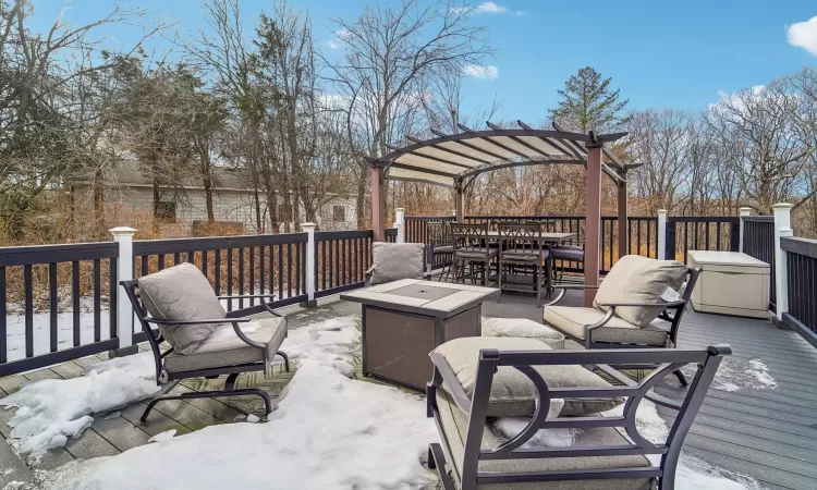 Wooden deck featuring a pergola and an outdoor fire pit