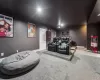 Carpeted home theater room featuring a baseboard heating unit