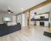 Living room featuring a barn door, light wood-type flooring, sink, and ceiling fan