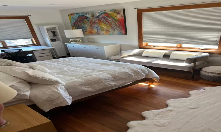 Bedroom with dark hardwood / wood-style flooring