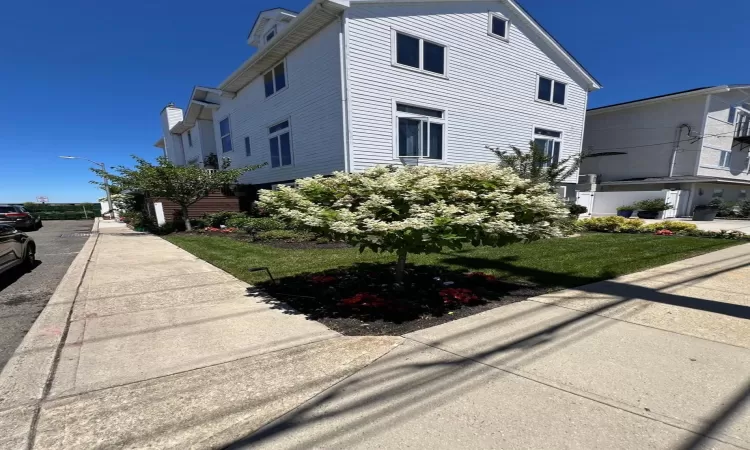 View of side of property with a lawn