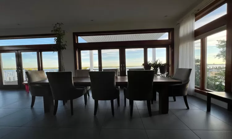 Dining room featuring a water view, a healthy amount of sunlight, and french doors