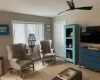 Living area with ceiling fan, a baseboard heating unit, and light tile patterned floors