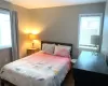 Bedroom featuring multiple windows and dark wood-type flooring