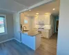 Kitchen with white cabinetry, sink, white appliances, and light stone countertops