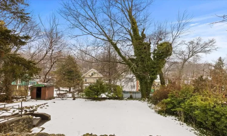 Yard covered in snow with a storage shed