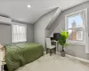 Bedroom featuring multiple windows, light colored carpet, vaulted ceiling, and a wall unit AC