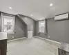 Bonus room featuring light colored carpet, plenty of natural light, a wall unit AC, and lofted ceiling