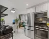 Kitchen with white cabinetry, backsplash, and appliances with stainless steel finishes