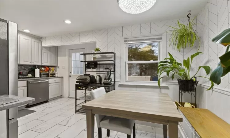 Kitchen with stainless steel dishwasher and decorative backsplash