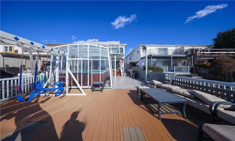 Wooden terrace with a pool and a lanai