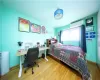 Bedroom with light hardwood / wood-style flooring and an AC wall unit