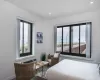 Bedroom with multiple windows, a wall mounted AC, and a water view