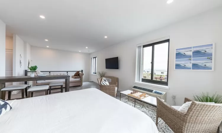 Bedroom with wood-type flooring and a wall mounted AC