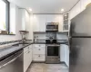 Kitchen featuring white cabinetry, appliances with stainless steel finishes, sink, and dark stone counters