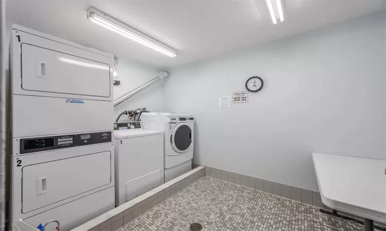 Clothes washing area featuring separate washer and dryer, stacked washer / drying machine, and tile patterned floors