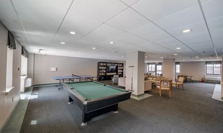 Rec room with carpet, a wealth of natural light, pool table, and a paneled ceiling