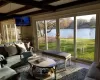 Sunroom with beam ceiling, a wealth of natural light, and a water view