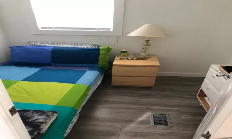 Bedroom featuring dark vinyl style floors