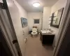 Bathroom with tile patterned floors, toilet, vanity, and a baseboard heating unit