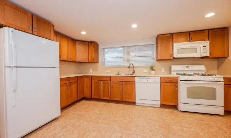 Kitchen featuring white appliances and sink