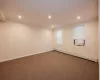 Carpeted empty room featuring a baseboard radiator and ornamental molding