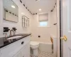 Full bathroom with tiled shower / bath combo, vanity, tile walls, and toilet