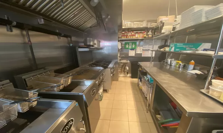 Kitchen featuring light tile patterned floors and stainless steel counters