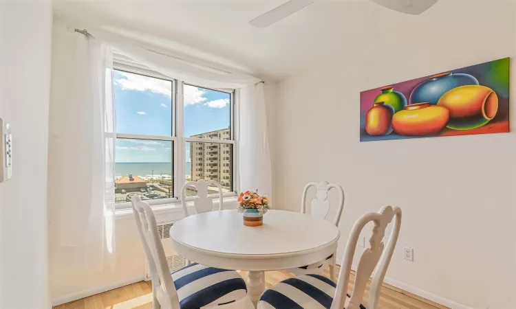 Dining room with light hardwood / wood-style floors and a water view