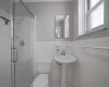 Bathroom featuring tile walls, toilet, and walk in shower