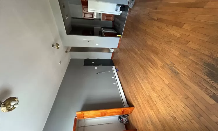 Unfurnished living room featuring light wood-type flooring and baseboard heating