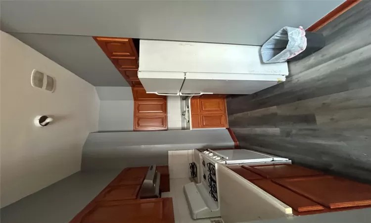 Kitchen featuring sink, range, ventilation hood, refrigerator, and dark hardwood / wood-style flooring