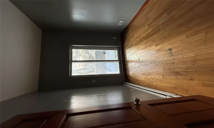 Spare room with a baseboard heating unit and light wood-type flooring