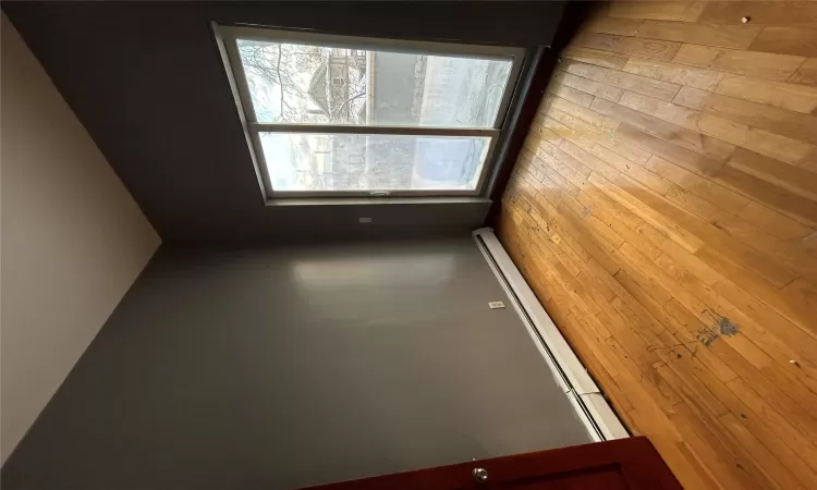 Spare room featuring baseboard heating and light hardwood / wood-style flooring