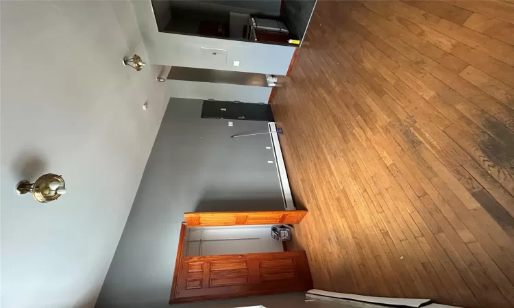 Unfurnished living room featuring a baseboard heating unit and light wood-type flooring