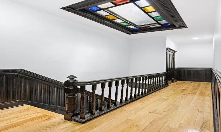 Staircase with wood-type flooring and wooden walls