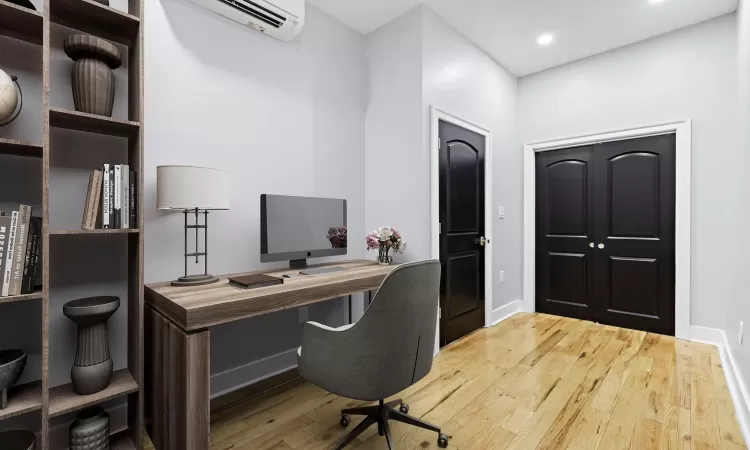 Office featuring a wall unit AC and light hardwood / wood-style flooring