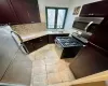 Kitchen featuring stainless steel appliances, sink, dark brown cabinets, tasteful backsplash, and light tile patterned floors