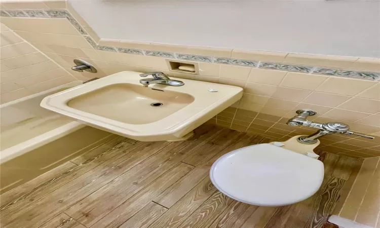 Bathroom with tile walls, sink, and hardwood / wood-style floors