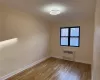 Empty room featuring radiator heating unit and light wood-type flooring