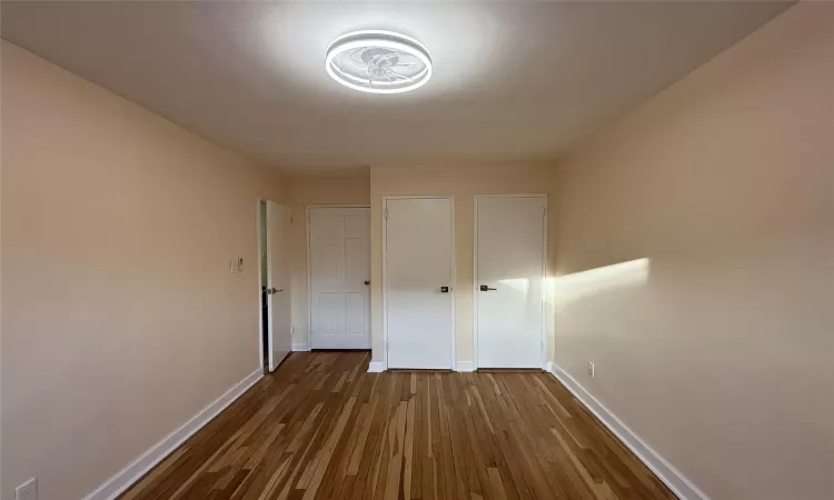 Unfurnished bedroom with hardwood / wood-style flooring