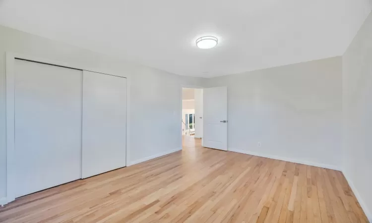 Unfurnished bedroom featuring light wood-type flooring and a closet