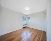 Unfurnished bedroom with radiator heating unit and light hardwood / wood-style flooring