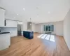 Kitchen with pendant lighting, blue cabinetry, a kitchen island, radiator heating unit, and stainless steel refrigerator