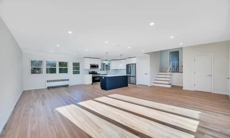 Unfurnished living room with radiator and light hardwood / wood-style flooring