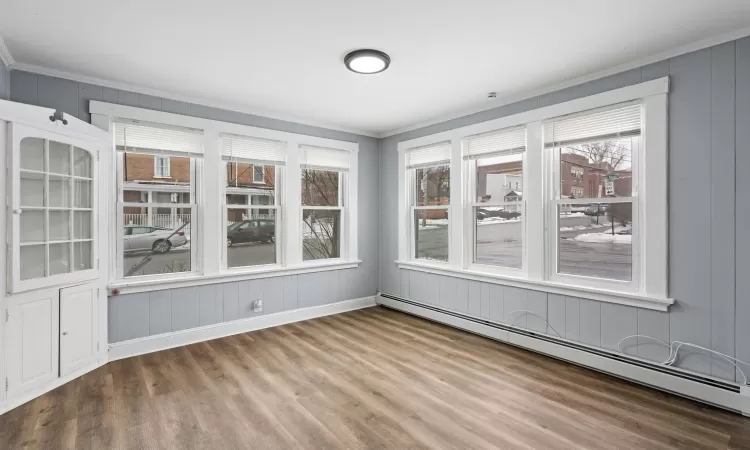 Unfurnished sunroom featuring a baseboard heating unit