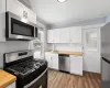 Kitchen with wood counters, stainless steel appliances, and white cabinets