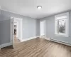 Spare room featuring hardwood / wood-style flooring, crown molding, and a baseboard radiator