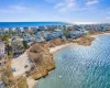 Birds eye view of property featuring a water view and a view of the beach