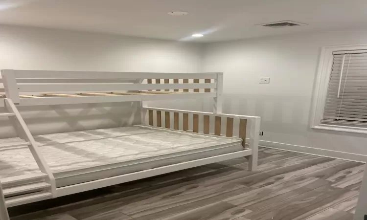 Unfurnished bedroom with hardwood / wood-style floors